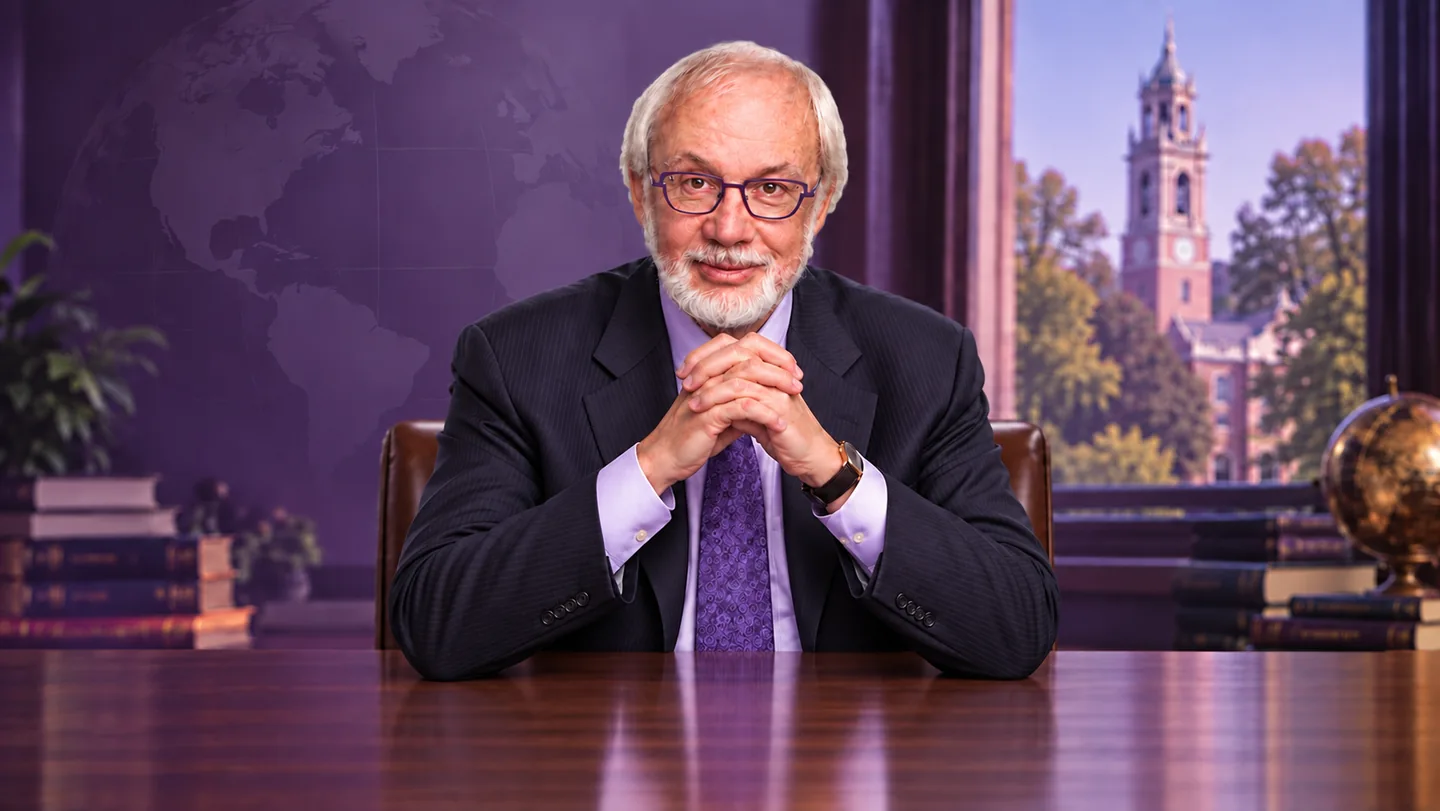 AI-assisted design portrait of Robert G. Eccles wearing purple glasses, seated with clasped hands in a study