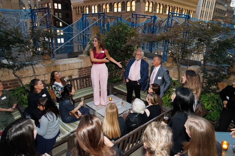 A group gathered around Bob and fellow attendees on a terrace during Climate Week